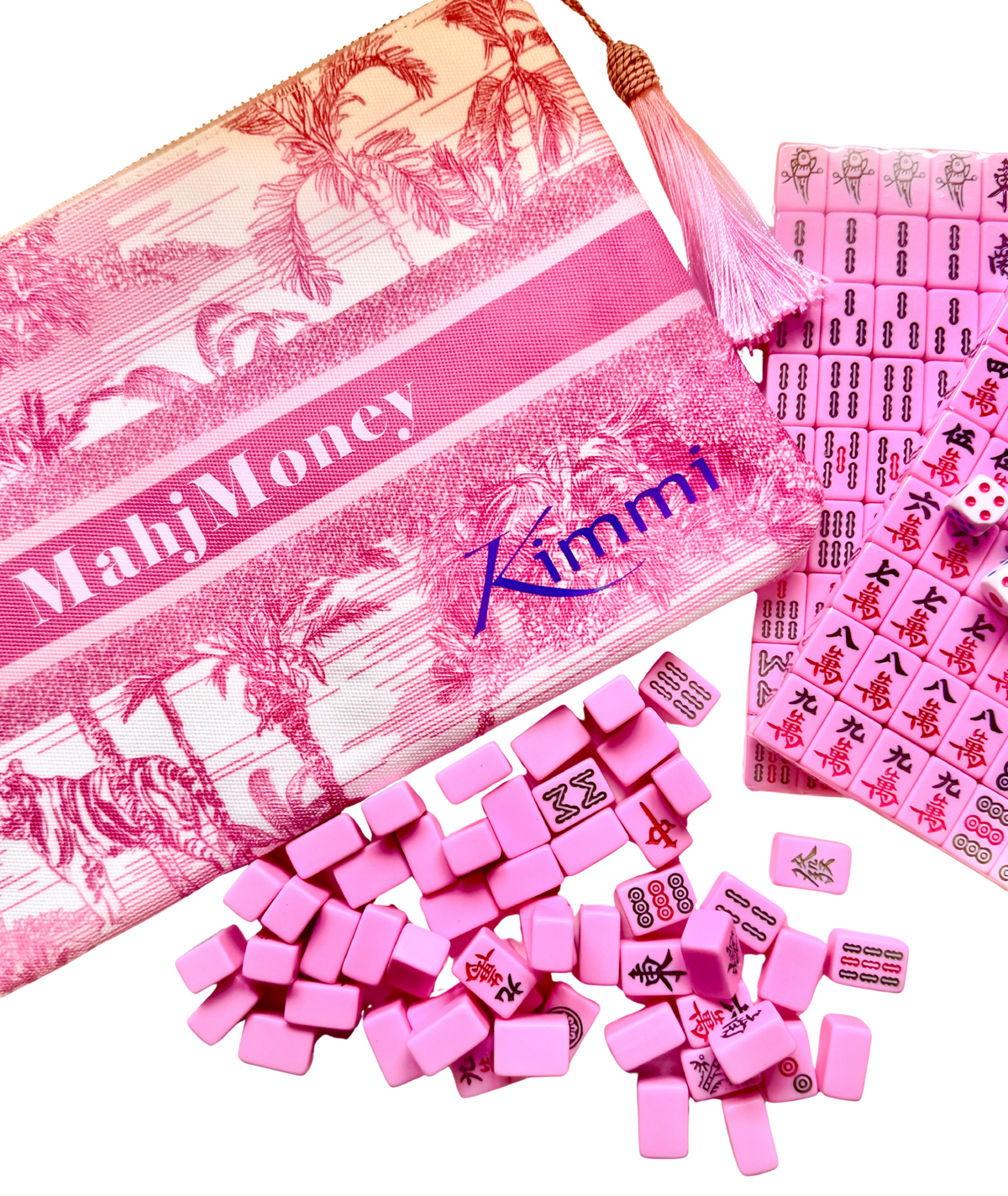 Pink Mahj Money game set by Kimmi, featuring a zippered pouch with a tropical print and tassel, scattered pink tiles, dice, and a board of matching pink cards on a white background.